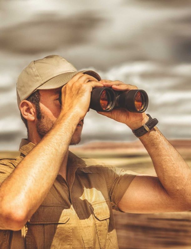 wildlife enthusiast looking at wildlife through binoculars