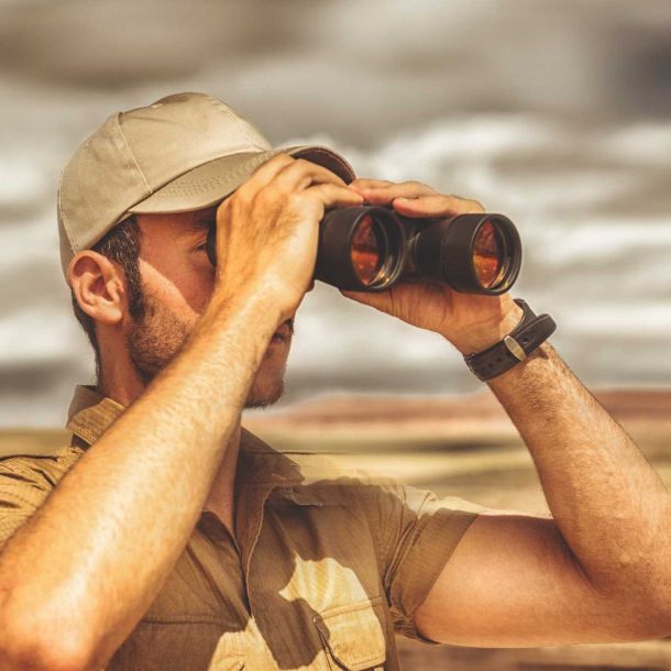 wildlife enthusiast looking at wildlife through binoculars